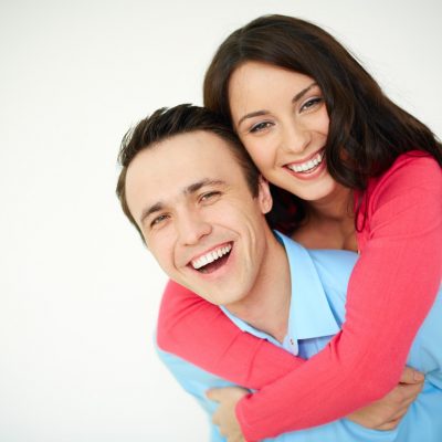 Portrait of amorous young woman embracing her happy husband